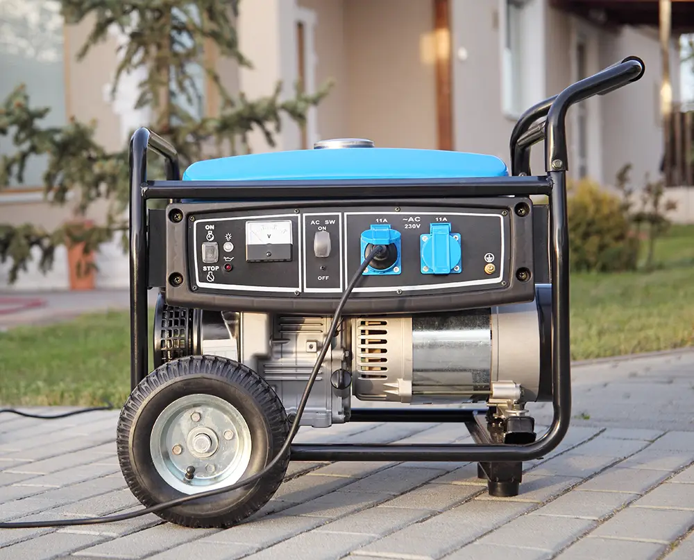 Portable generator with a connected power cord on a paved patio outside a home in Belleville, IL.