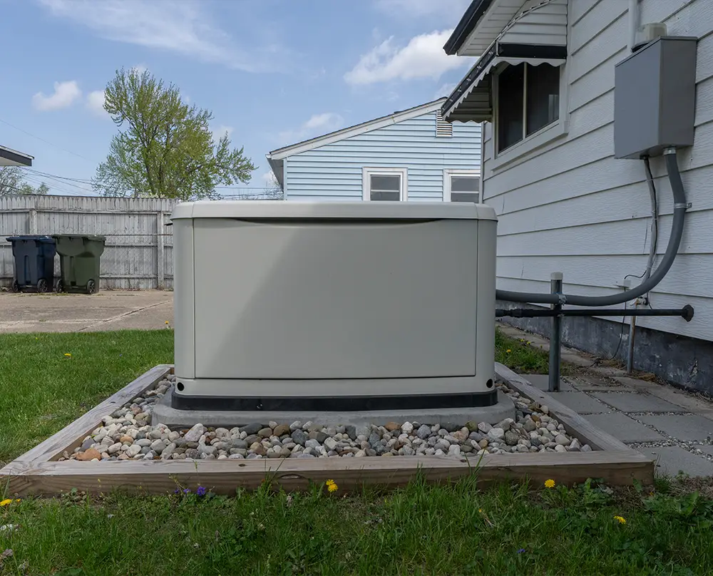 Residential standby generator on a gravel-bordered pad beside a home in Belleville, IL.